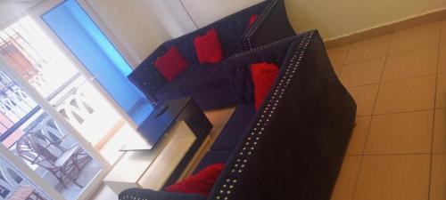 a room with a bed with red pillows at Lovely and spacious apartment with swimming pool in Mtwapa