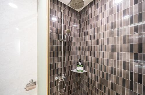 uma casa de banho com chuveiro e azulejos castanhos em Wate Hotel em Yeosu