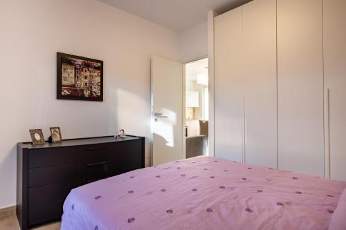 um quarto com uma cama rosa e uma cómoda em Casadamare Salento em Brindisi