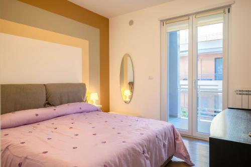 a bedroom with a pink bed and a large window at Casadamare Salento in Brindisi