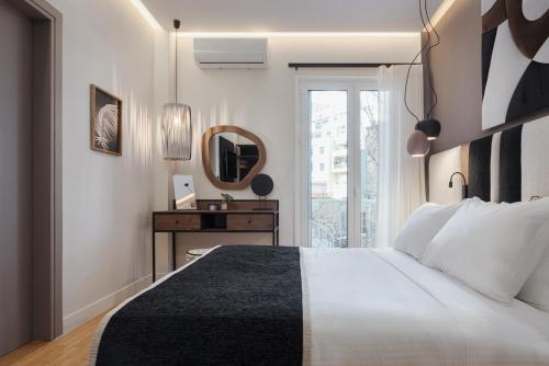um quarto com uma cama grande e um espelho em Acropolis Elite Residences em Atenas