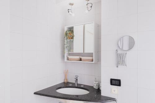 uma casa de banho com um lavatório e um espelho em Stylish and Cozy apt close to Naviglio (MUDEC) em Milão