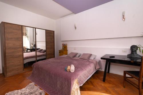 a bedroom with a bed and a desk and a table at Shared Retro Vintage Luxury Apartment in Bucharest