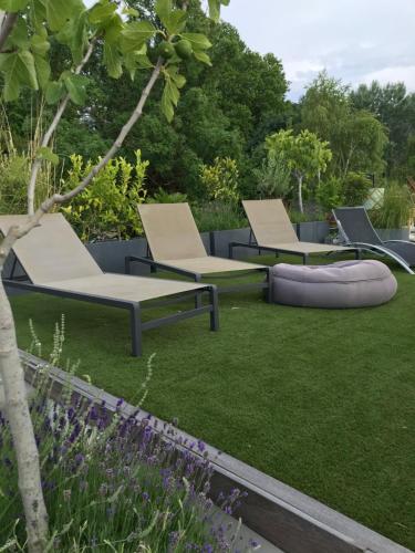 3 chaises longues sur l'herbe dans un jardin dans l'établissement Loft sur l'eau avec parking, à Paris