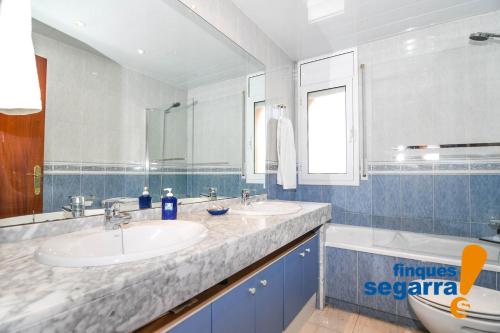 uma casa de banho com 2 lavatórios e um espelho grande em Casa Greco em Comarruga