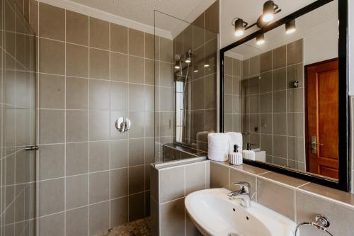 a bathroom with a sink and a mirror at Fritz Manor Bed and Breakfast in Swakopmund