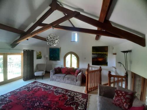 a living room with a couch and a red rug at Stunning Coastal Barn Conversion in Kingsbridge