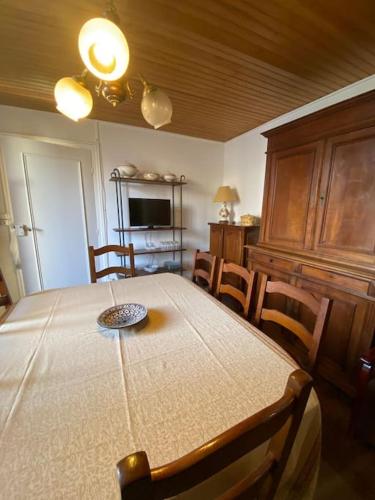 une salle à manger avec une table, des chaises et une télévision dans l'établissement Le NEW Montferrand 1 et 2, à Clermont-Ferrand