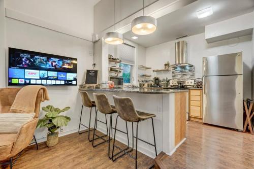 a kitchen with a bar with stools and a refrigerator at Miners Anvil - Steps to Historic District in Colorado Springs