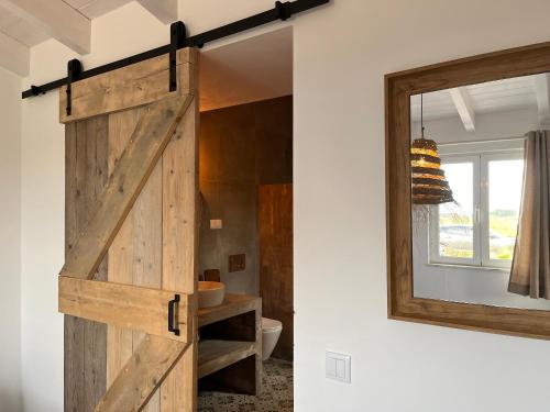 una porta del fienile in un bagno con specchio di Sun, Sea, Nature ad Aljezur