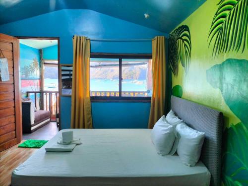 a bedroom with a bed with a large window at Gracias Place in El Nido
