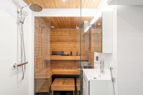 a bathroom with a shower and a tub with a sink at Kotimaailma - Furnished Apartment in Vantaa with key code in Vantaa