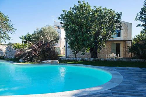 uma grande piscina azul em frente a uma casa em Villa Pruno - Happy Rentals em Scicli