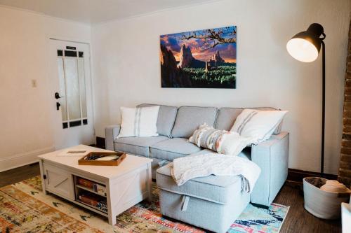 a living room with a blue couch and a table at Miners Bend - Historic Locale Scenic Workspace in Colorado Springs