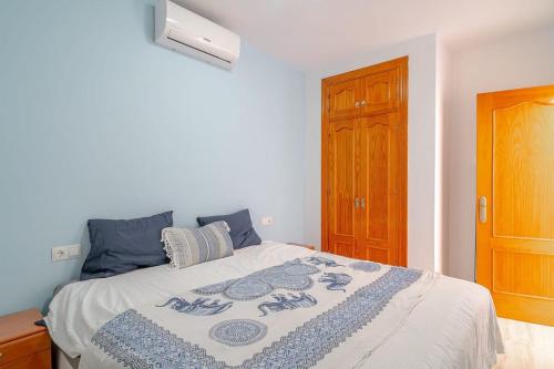 a bedroom with a bed with a blue and white blanket at Edf Papillon in Nerja