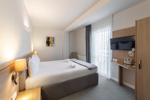 ein Hotelzimmer mit einem großen Bett und einem Fenster in der Unterkunft Eden 5 in Predeal
