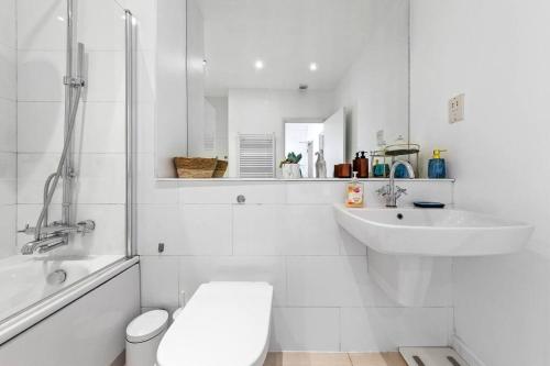 uma casa de banho branca com um WC e um lavatório em Luxurious 3 Bedroom Flat in Haymarket London Sleeps 14 HY1 em Londres