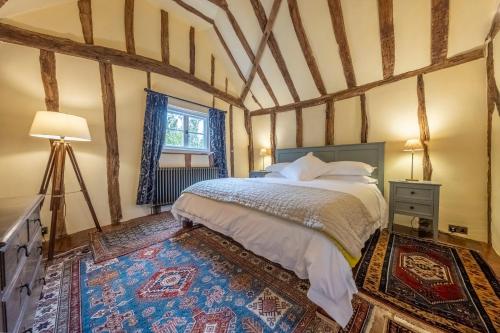 a bedroom with a bed and a window at Medieval cottage in rural village - Duke's Lodge in Bildeston