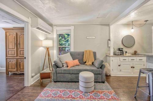 a living room with a couch and a kitchen at Miners Escape - Timeless District Cozy Haven in Colorado Springs
