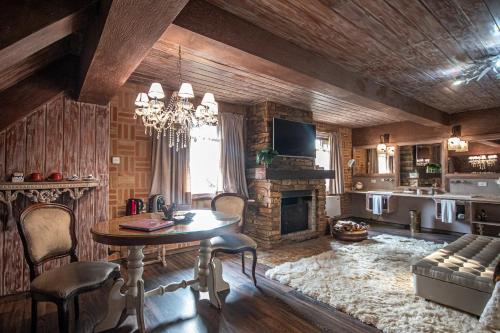 uma sala de estar com uma mesa e uma lareira em Chateau La Villette em Campos de Jordão