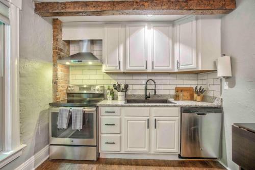 a kitchen with white cabinets and a sink at Miners Escape - Timeless District Cozy Haven in Colorado Springs