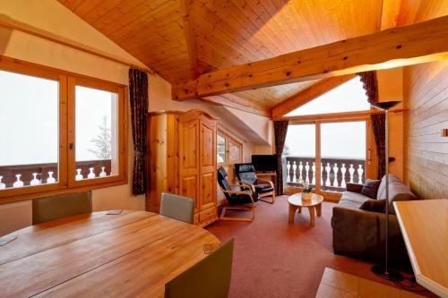 un salon avec une table en bois et un canapé dans l'établissement Hotel les Flocons, à Courchevel