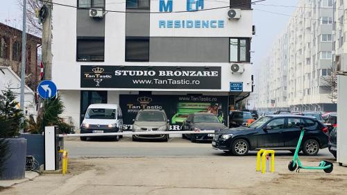 a parking lot with cars parked in front of a store at Apartament modern -with Free Parking in Chiajna