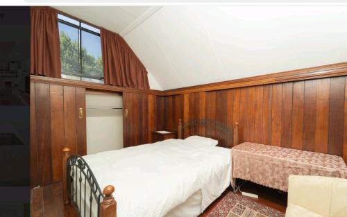 - une chambre dotée de lambris, d'un lit et d'une fenêtre dans l'établissement Quiet and peaceful Perth City living with free Parking, à Perth