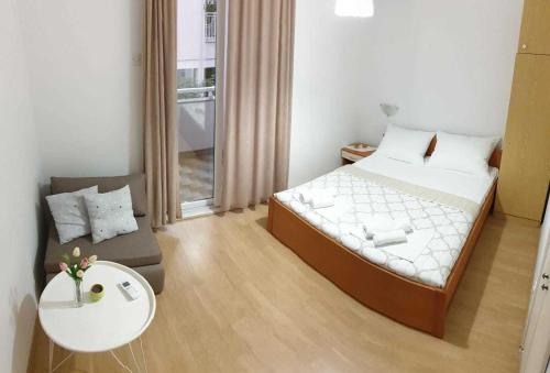 a bedroom with a bed and a table and a couch at Apartments Ruzinka in Podaca