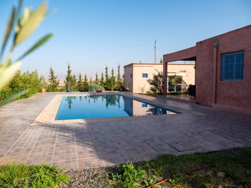 a swimming pool in a yard next to a building at Agafay Olivium 