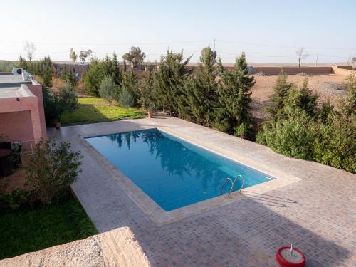 a swimming pool in the middle of a yard at Agafay Olivium 
