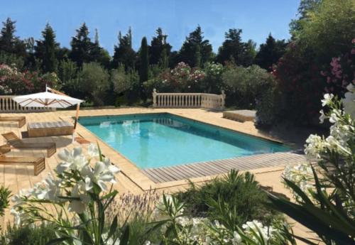 una piscina en un jardín con flores en Les Jardins du Soleil, en Aviñón