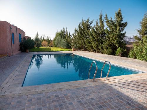 a swimming pool with two metal chairs next to it at Agafay Olivium 