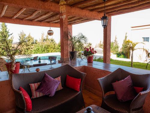 a patio with chairs and a bar with a table at Agafay Olivium 