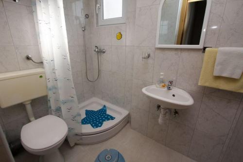 a bathroom with a shower toilet and a sink at Apartments Ruzinka in Podaca