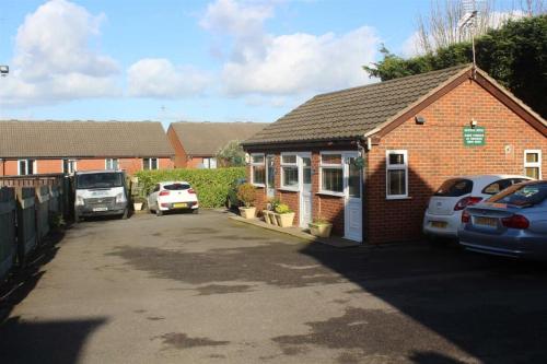 a brick house with cars parked in a driveway at Central Hotel in Sutton in Ashfield