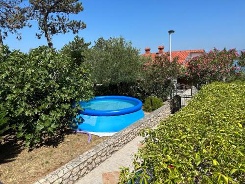 a large blue tub in a garden with bushes at Villa Nika in Klimno