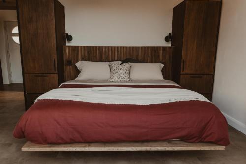 a large bed with a wooden headboard in a bedroom at Modern log cabin with hot tub in Newtown