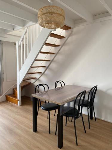 une table à manger avec des chaises et un escalier dans l'établissement Ty Duplex, à Quiberon