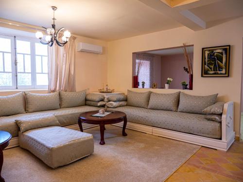 a living room with a couch and a table at Agafay Olivium 