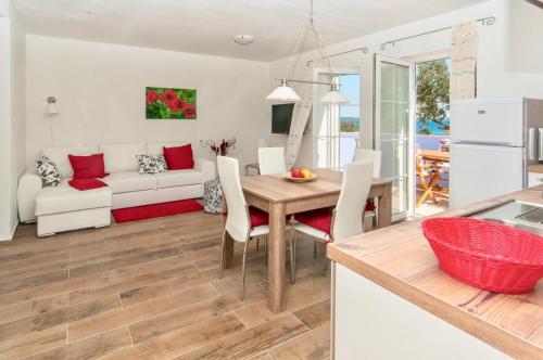 a kitchen and living room with a table and a couch at Villa EVITA with sea view in Nerezine