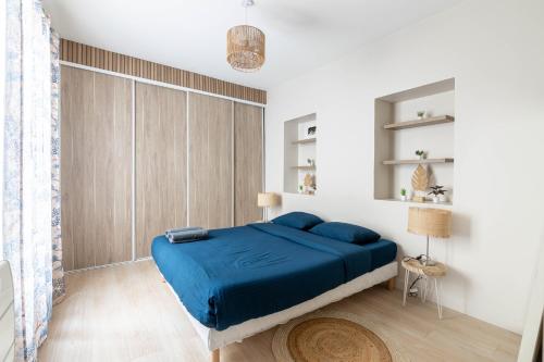 a bedroom with a blue bed in a white room at Luxurious 1 Bedroom Quartier de la Bastille Free Netflix in Paris