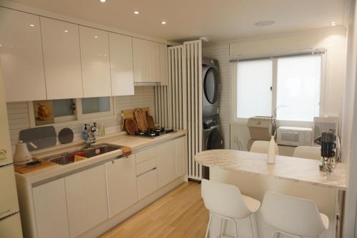 une cuisine avec des placards blancs et un comptoir dans l'établissement NEW OPEN-Oublier,SEOUL STN 5min by walk,Cozy Home, à Séoul