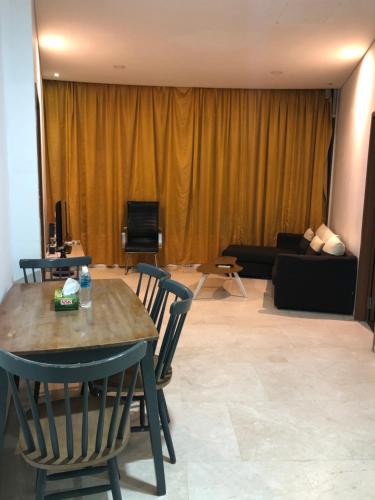 Vortex Suites KLCC by Luna في كوالالمبور: غرفة معيشة مع طاولة وكراسي وأريكة