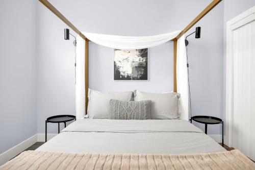 een slaapkamer met een wit bed en 2 zwarte stoelen bij NoHo by AvantStay North Hollywood Townhome in Los Angeles