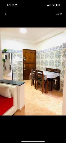 uma sala de jantar com uma mesa e cadeiras num quarto em Appartement meublé em Rabat