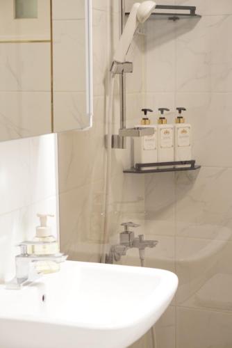 een witte badkamer met een wastafel en een spiegel bij NEW OPEN-Oublier,SEOUL STN 5min by walk,Cozy Home in Seoul