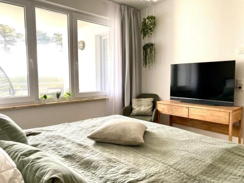 a bedroom with a bed and a flat screen tv at Ferienwohnung Dünensegler in Juliusruh