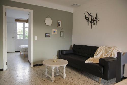 - un salon avec un canapé noir et une table dans l'établissement El Solà - Appartement avec accès jardin, à Corneilla-de-Conflent