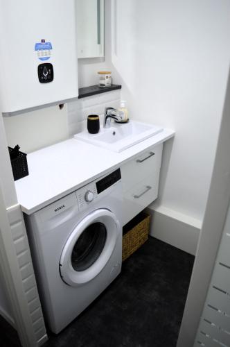 a bathroom with a washing machine and a sink at L'Esperluette - magnifique vue mer et balcon in Courseulles-sur-Mer